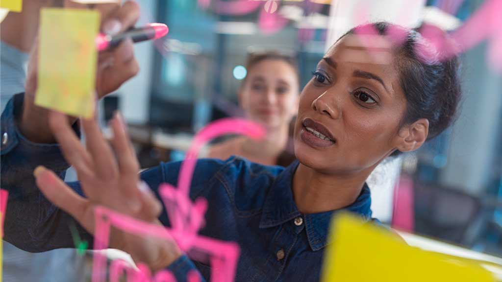 Profissional desenhando estratégias de brandformance durante uma reunião colaborativa