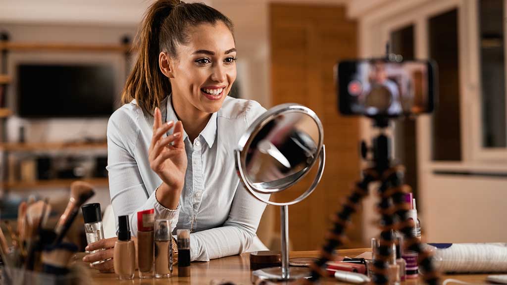 Mulher grava vídeo mostrando produtos de maquiagem como parte de uma estratégia UGC para divulgar marcas de beleza
