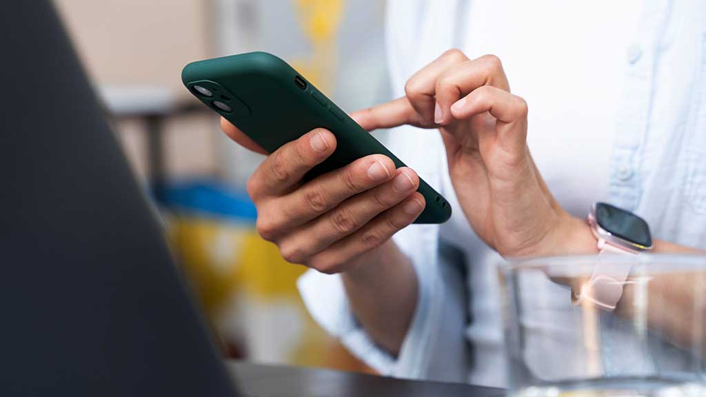 Pessoa usando o celular para atendimento via WhatsApp Business