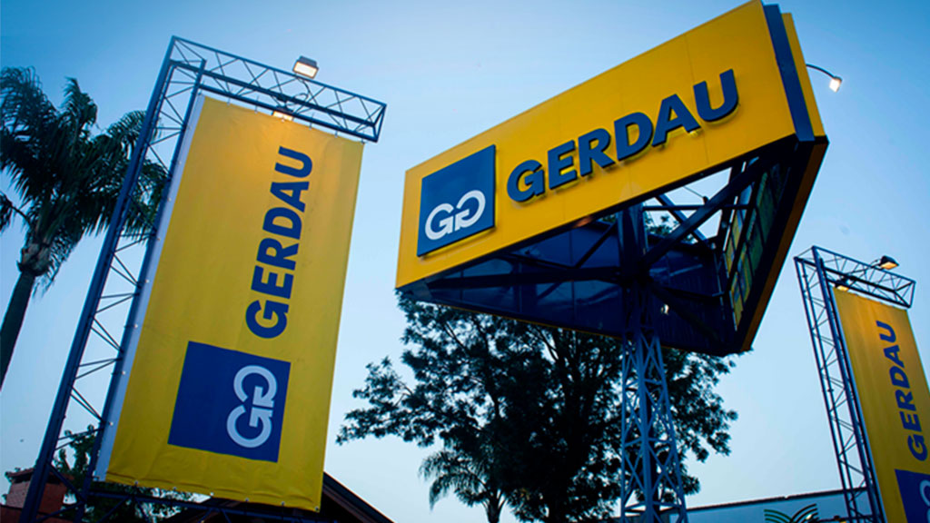 Fachada da empresa Gerdau com letreiros e bandeiras amarelas e azuis em estrutura metálica externa